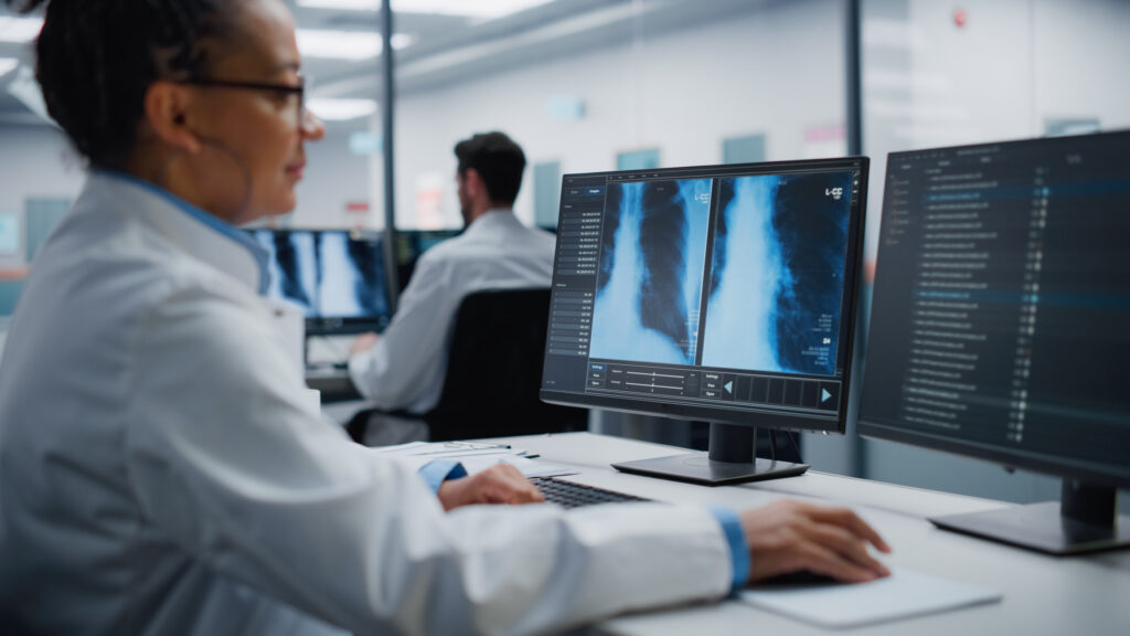 Modern Hospital Laboratory: Black Female Medical Doctor is Working on Computer Analysing Chest, Bones X-rays on Screen. Professional African American Physician Doing High-Tech Treatment Research
