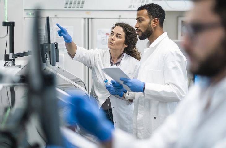 Laboratory team reviewing diagnostic equipment together