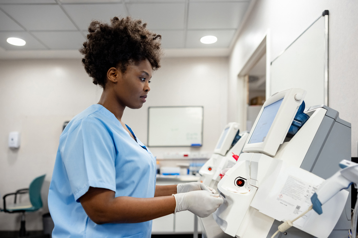 Health worker operating a diagnostic analyzer