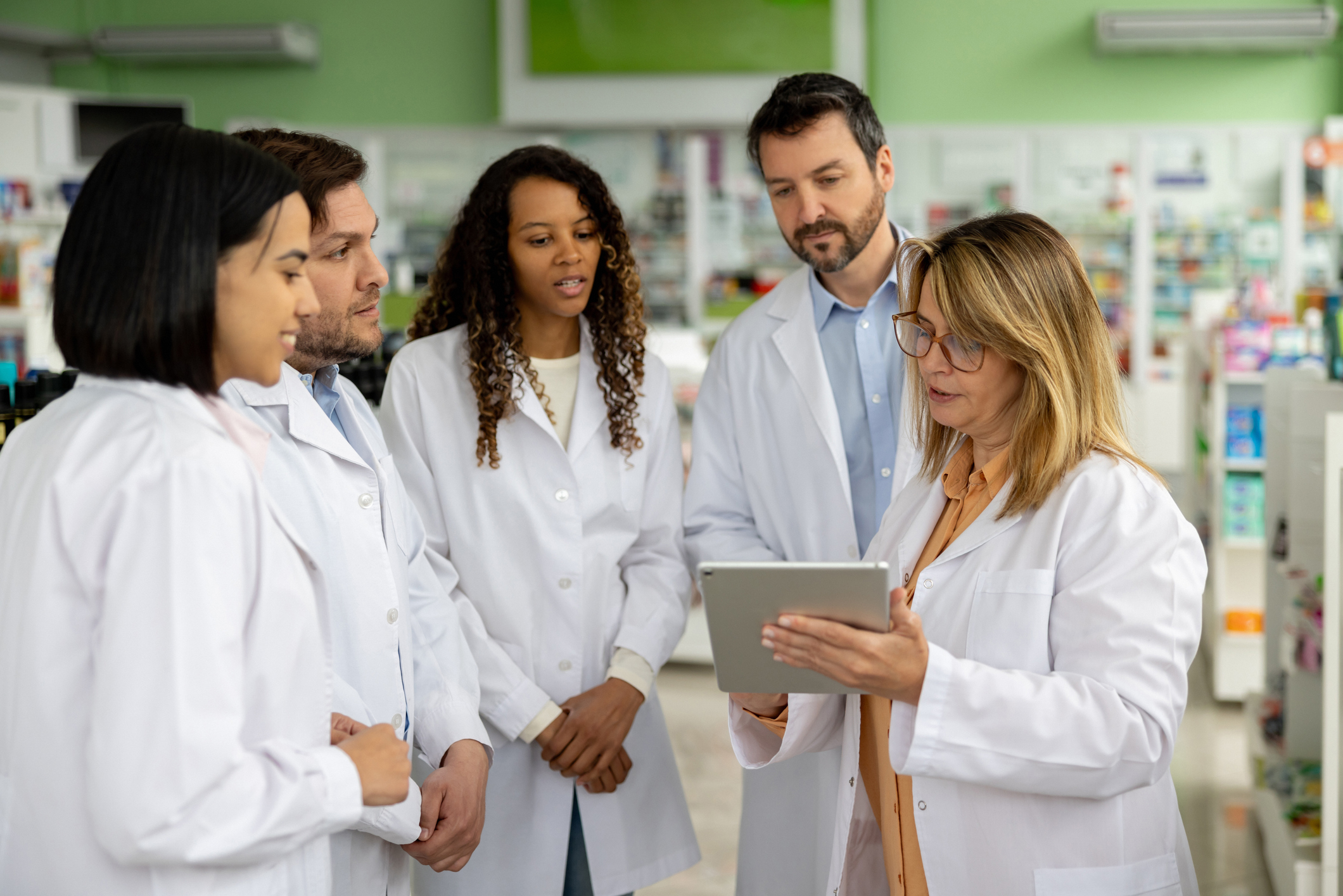 Pharmacist training a group of employees at a drugstore